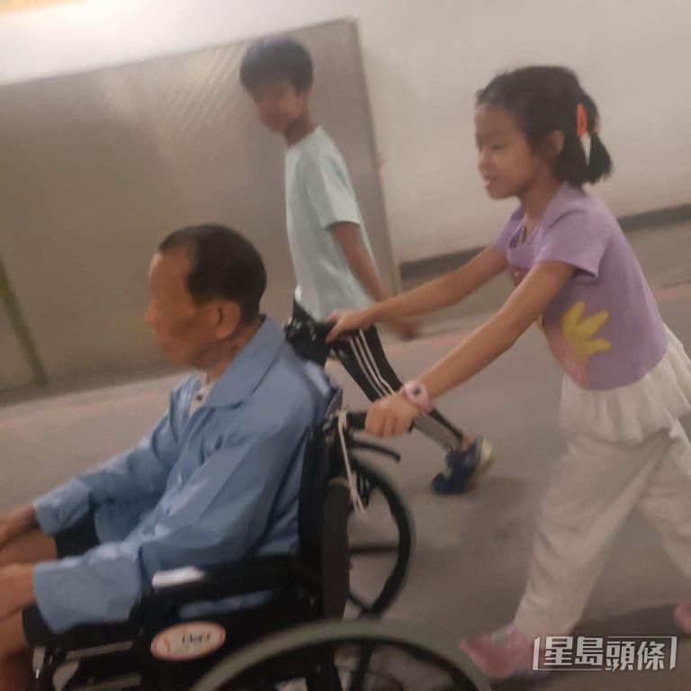 Alice的一双儿女陪同坐轮椅的外公上街。
